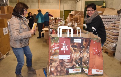 Freiwillige Verpacken Lebensmittel für die Spendenaktion 2xWeihnachten
